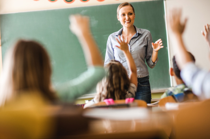 Laughing female teacher asks her class a question